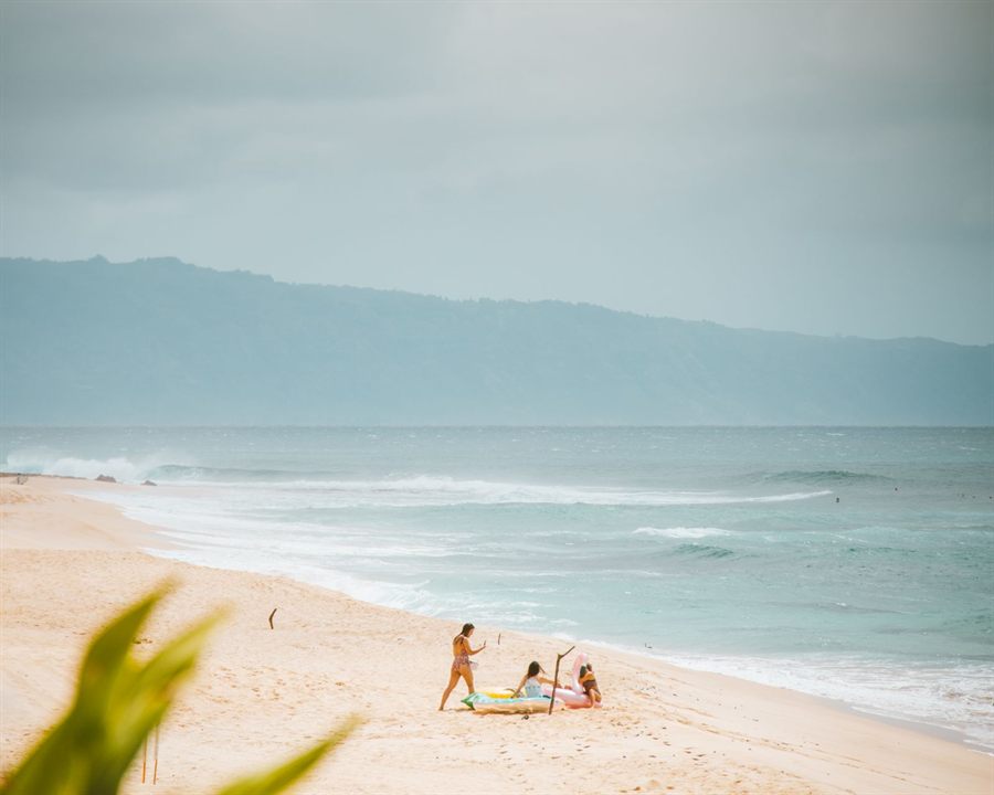 A few people relaxing on a quiet sandy beach at Pupukea on the North Shore of Oahu