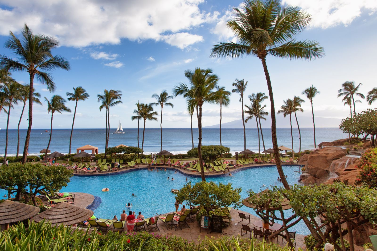Resort pool, palm trees and the ocean at Kaanapali on Maui, the kind of stay a land vacation offers